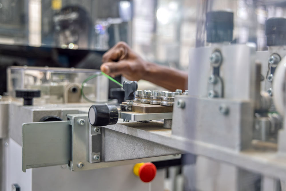 Car wire harness factory, wiring cable measure in a machine, african american workers hand